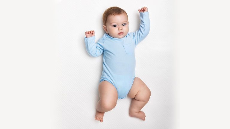 Baby lying on their back on a firm, flat mattress