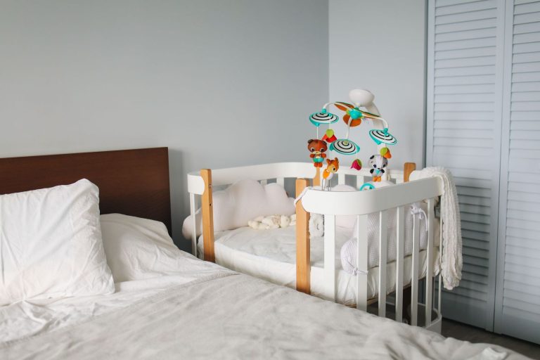 Crib placed next to the parents' bed for room-sharing