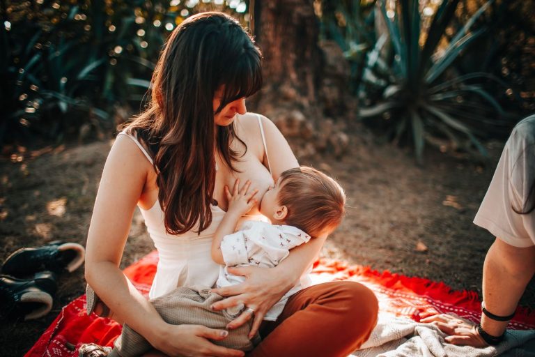 Mother breastfeeding her baby outdoors