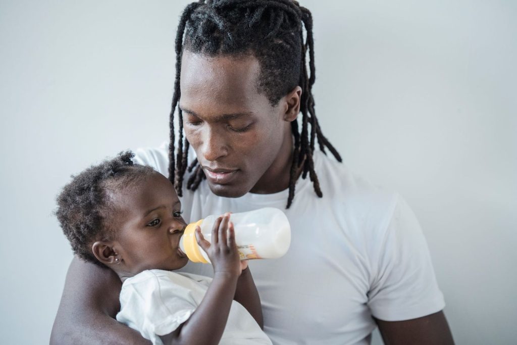 Father feeding his baby daughter with a bottle
