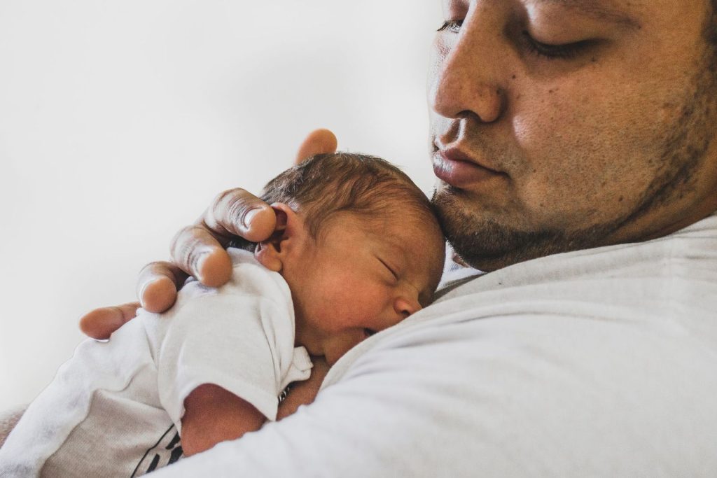 Father holding his sleeping newborn on his chest