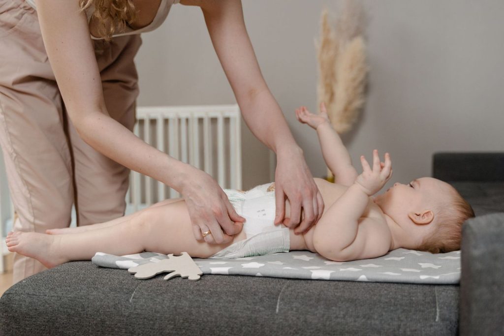 Parent changing a baby's diaper on a changing mat