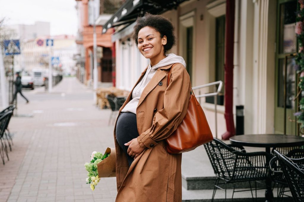 Smiling pregnant woman carrying a bag