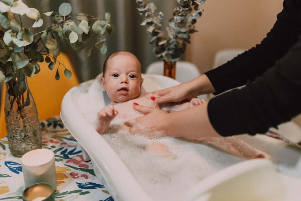 Mother bathing her baby in an infant tub