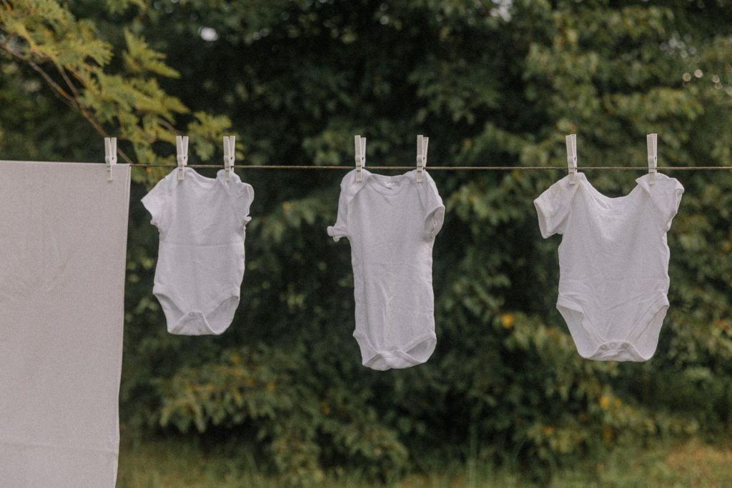 Baby bodysuits hanging on a clothesline