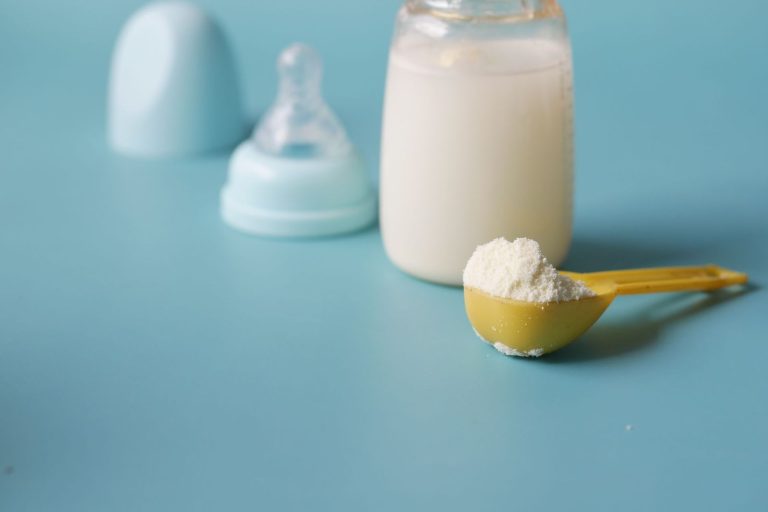 Baby bottles and a scoop of formula powder