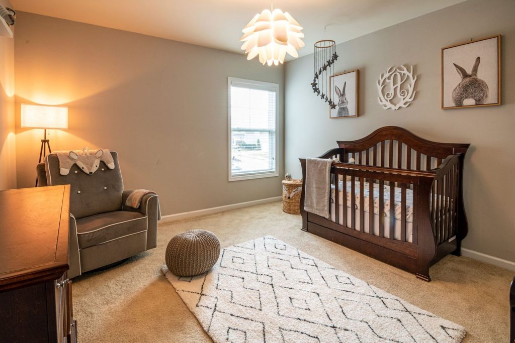 Nursery with a wooden crib, rocking chair and rug