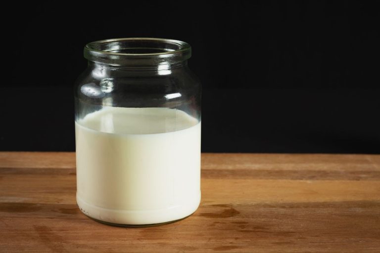 Glass jar of milk on a wooden table