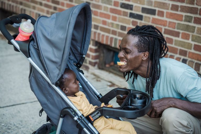 Father smiling at his baby in a stroller