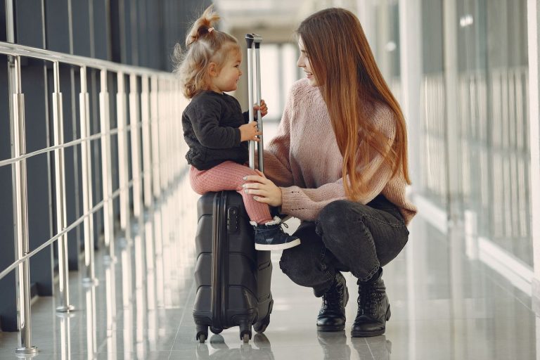 Mother and toddler with a suitcase at the airport