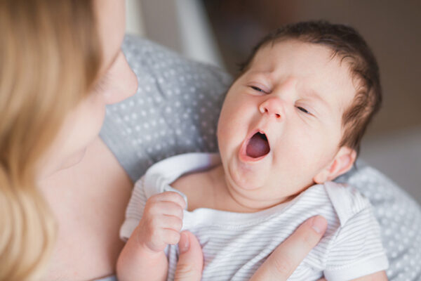 Baby yawning while being held — an early sleepy cue